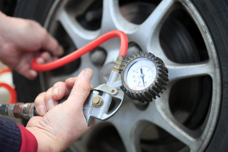 Comprobación y aumento de la presión de los neumáticos con un manómetro.
